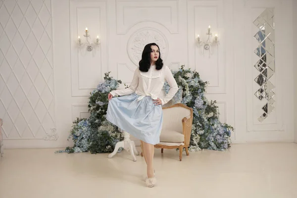 Lovely woman in retro cute cotton dress posing indoors in her white apartment. Fashion lady in vintage outfit with stockings. — Stock Photo, Image