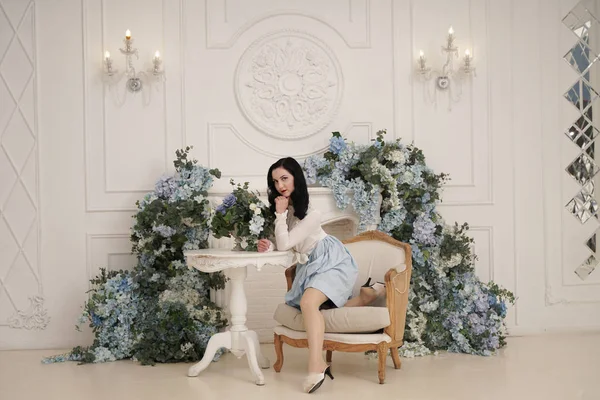 Mujer encantadora en retro lindo vestido de algodón posando en el interior de su apartamento blanco. Señora de la moda en traje vintage con medias . — Foto de Stock