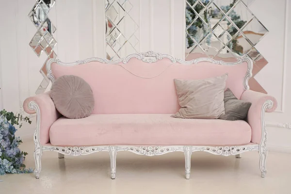 Sofá rosa viejo de moda con almohadas en habitación blanca con nadie —  Fotos de Stock