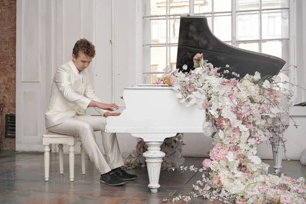 Joven adolescente hombre con blanco grande piano de cola en el interior solo disfruta de la música — Foto de Stock