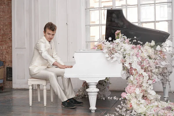 Joven adolescente hombre con blanco grande piano de cola en el interior solo disfruta de la música — Foto de Stock