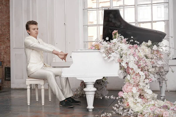 Ung tonåring man med vit stor flygel inomhus ensam åtnjuter musik — Stockfoto