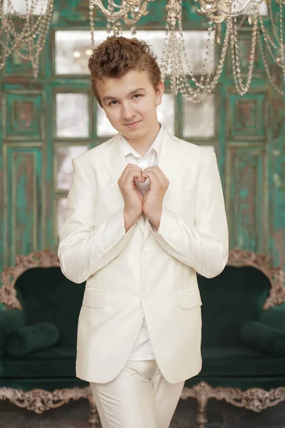 Vackra kaukasiska tonåring pojke visar Heart kärleks symbol av armar palmer ensam i vita kläder. — Stockfoto