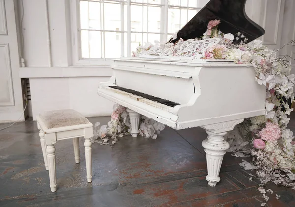 白色大钢琴与春天白色和粉红色的花朵在一个白色的房间，没有人 — 图库照片