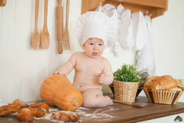 Маленька дитина пекарня в капелюсі шеф-кухаря за кухонним столом сам — стокове фото