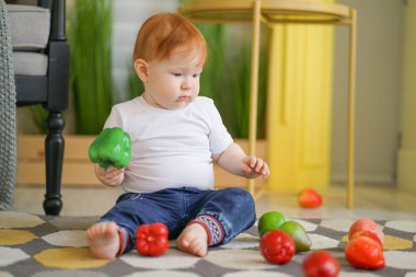 kırmızı saçlı tombul çocuk sebze ile oynar