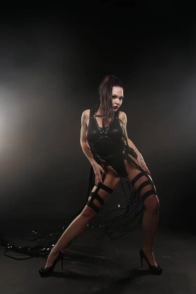 Bela corrida mistura delgado dançarina muscular menina posando em um maiô preto com arnês de couro com fitas de vídeo — Fotografia de Stock