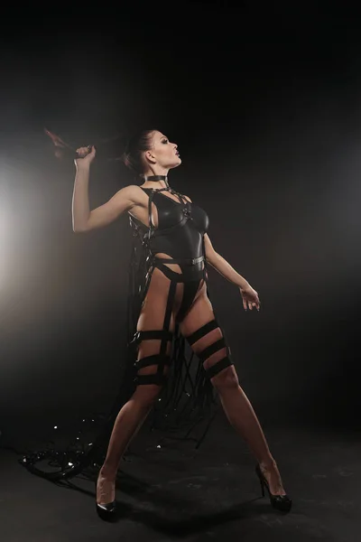 Schöne Mischung Rennen schlanke muskulöse Tänzerin Mädchen posiert in einem schwarzen Badeanzug mit Ledergeschirr mit Videobändern — Stockfoto