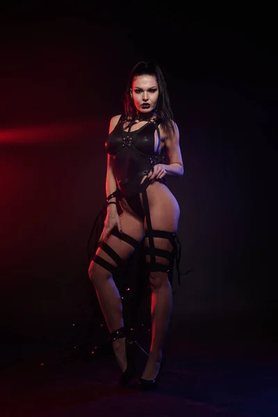 Hermosa mezcla de raza esbelta bailarina muscular posando en un traje de baño negro con arnés de cuero con cintas de vídeo — Foto de Stock