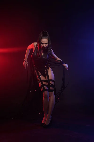Vacker mix Race smal muskulös dansare flicka poserar i en svart baddräkt med läder sele med videoband band — Stockfoto