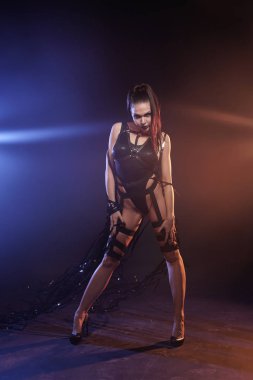 güzel mix yarış ince kaslı dansçı kız video kaset bantları ile deri koşum ile siyah bir mayo poz