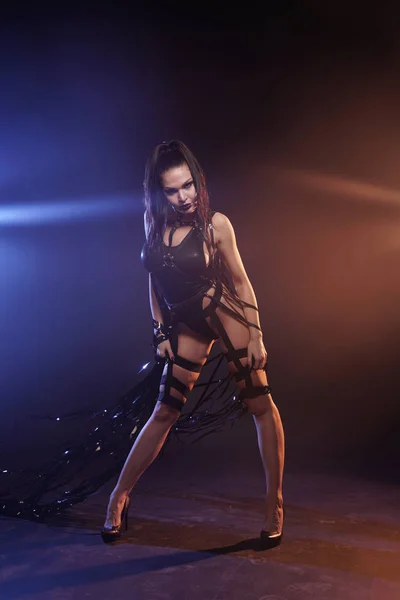 Hermosa mezcla de raza esbelta bailarina muscular posando en un traje de baño negro con arnés de cuero con cintas de vídeo — Foto de Stock