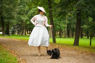 Parkta onu siyah kedi maine coon ile yürüyüş Pretty vintage kadın
