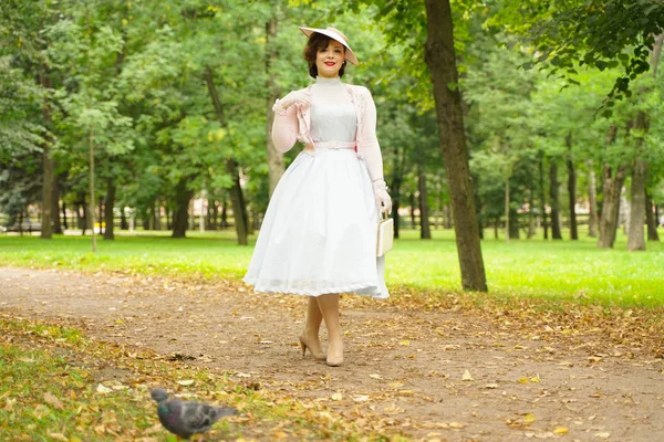 Portrét špendlíku mladé ženy ve starožitným kostýmu a chůzi na retro kloboučku — Stock fotografie
