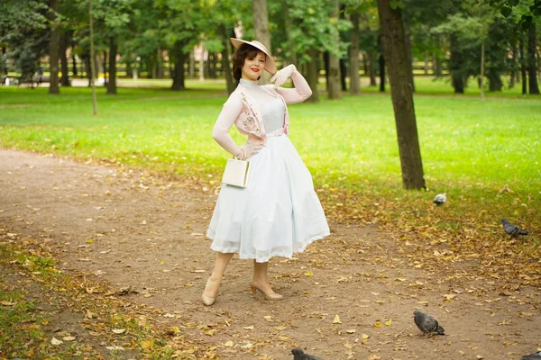 Portret van pin-up jonge vrouw in Vintage jurk en retro hoed wandelen — Stockfoto