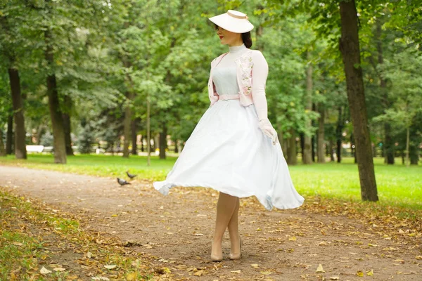 Retrato de pin up mujer joven en vestido vintage y sombrero retro caminando —  Fotos de Stock
