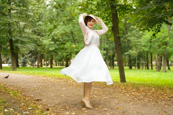 Retrato de pin up mujer joven en vestido vintage y sombrero retro caminando — Foto de Stock