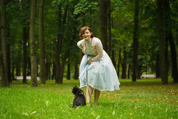 Jolie femme vintage marchant avec son chat noir maine coon dans le parc — Photo