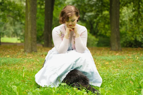 Mooie vintage vrouw wandelen met haar zwarte kat Maine Coon in het Park — Stockfoto