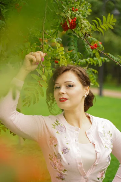 Mulher bonita escolhendo chokeberry no país — Fotografia de Stock
