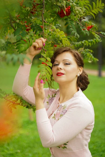 Mulher bonita escolhendo chokeberry no país — Fotografia de Stock