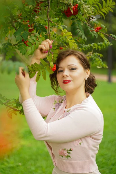 Mulher bonita escolhendo chokeberry no país — Fotografia de Stock