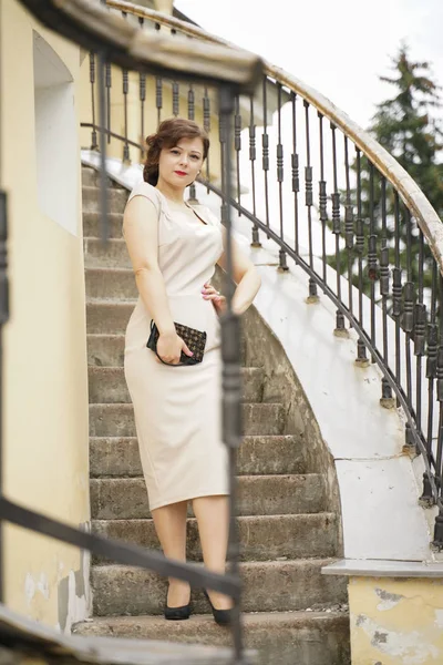 Mode Porträtt av ung kvinna i klassisk Pinup beige klänning utomhus i staden — Stockfoto