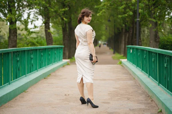 Mode portret van jonge vrouw in klassieke Pinup beige jurk buiten in de stad — Stockfoto