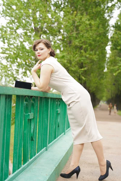 Mode portret van jonge vrouw in klassieke Pinup beige jurk buiten in de stad — Stockfoto