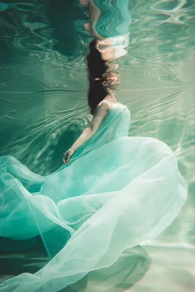 Mujer joven nadando sola con tela de moda bajo el agua de incógnito — Foto de Stock