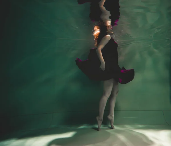 Jovem nadando sozinho com tecido de moda subaquática incógnito — Fotografia de Stock