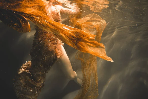 Jovem nadando sozinho com tecido de moda subaquática incógnito — Fotografia de Stock