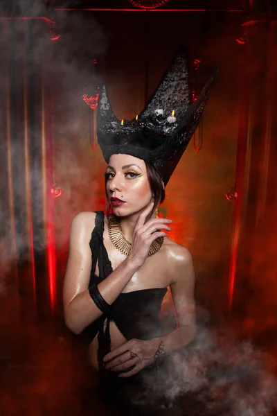 Evil stylish woman witch with big black hat on dark scary smoky background alone — Stock Photo, Image