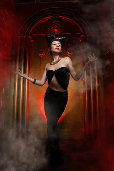 Evil stylish woman witch with big black hat on dark scary smoky background alone — Stock Photo, Image