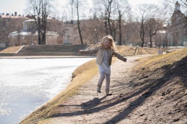 Çocuk mutlu atlama ve yalnız soğuk bahar şehir parkı çalışan