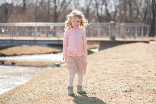 市内の公園で一人歩く小さな女の子とお楽しみください. — ストック写真