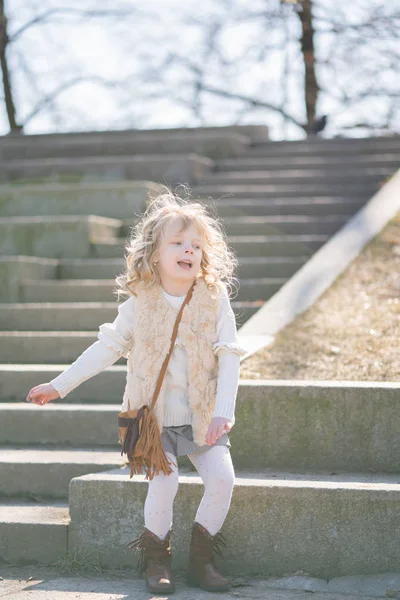 Liten flicka gå ensam i stadsparken och njuta av. — Stockfoto