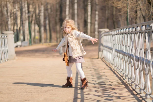 Liten flicka gå ensam i stadsparken och njuta av. — Stockfoto