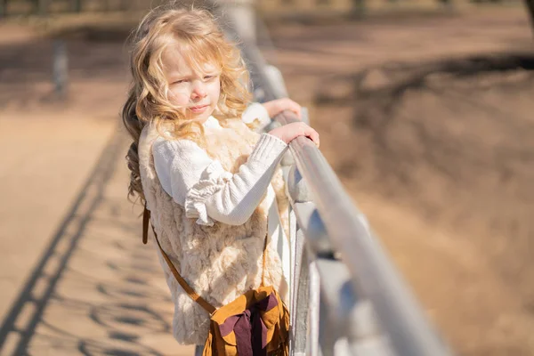 Маленькая девочка гуляет одна в городском парке и наслаждается . — стоковое фото