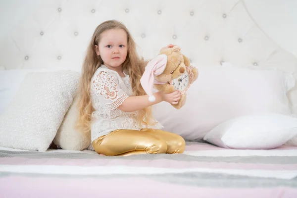 Hodná holčička má ráda ráno. Dobré ráno doma. Dívka na bílém lůžku sama. — Stock fotografie