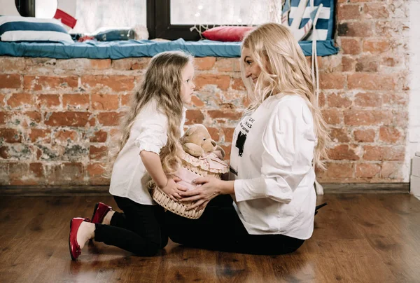 Szép szőke anya és az ő kaukázusi kislánya ül a padlón nagy doboz ajándékot, és boldog együtt — Stock Fotó