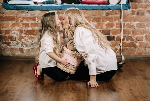 Bonita mãe loira e sua filha caucasiana sentada no chão com grande presente caixa e feliz juntos — Fotografia de Stock