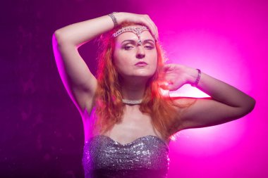 Olgun artı boyutu gri gece elbisesi içinde kırmızı saçlı kadın cadılar bayramı için hazır koyu duman arka plan üzerinde poz.