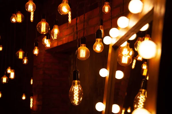 Clásico diferentes bombillas retro colgando en el fondo de la pared de ladrillo por la noche — Foto de Stock