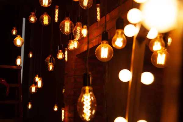 Klassische verschiedene Retro-Glühbirnen hängen in der Nacht auf Backsteinwand Hintergrund — Stockfoto