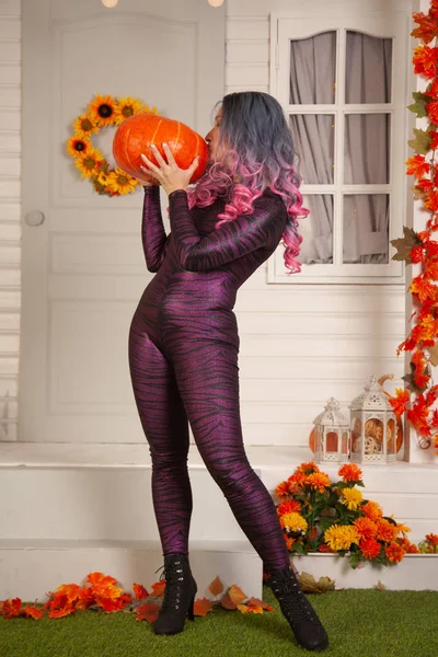 Hübsche Halloween-Frau im engen Tiger-Jumpsuit bereit zum Feiern und Warten auf Freunde für eine Party im Freien — Stockfoto