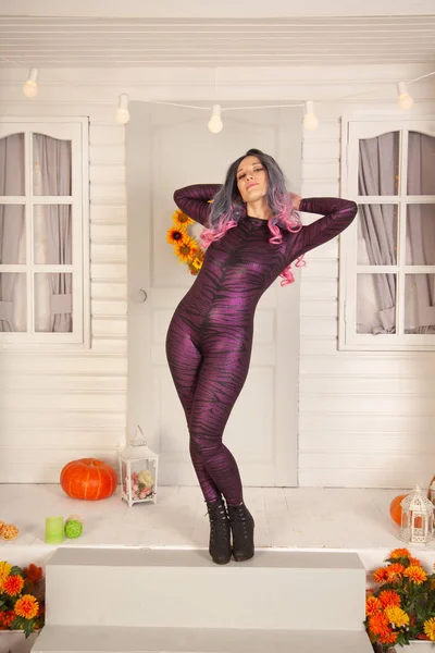Pretty halloween woman in tight tiger jumpsuit ready to celebrate and waiting for friends for a party outdoor — Stock Photo, Image