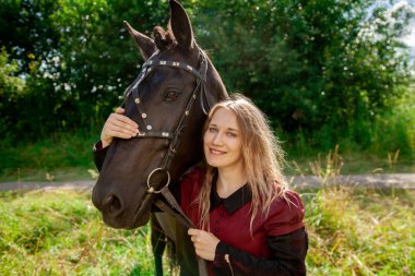 Güzel beyaz kız bir atla yürüyor ve yaz tatilini kırsalda geçiriyor..