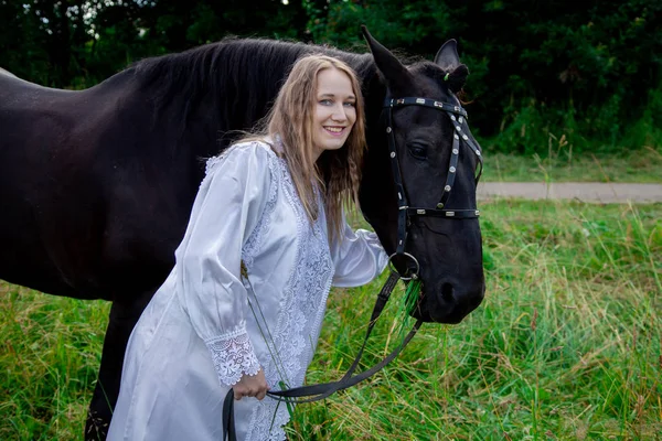 Schöne kaukasische junge Mädchen zu Fuß mit einem Pferd und genießt die Sommerzeit in der Natur. — Stockfoto