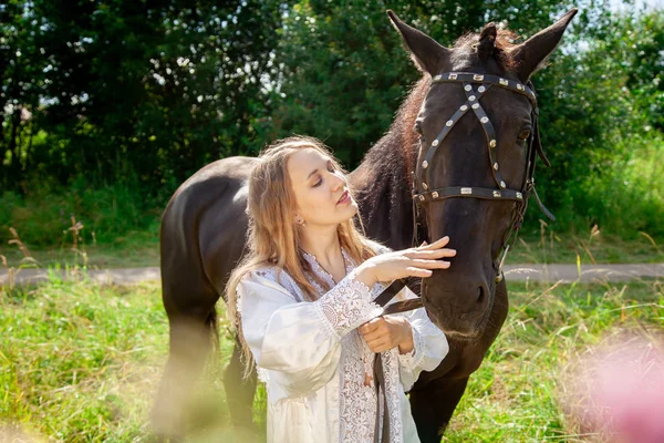 Piękne kaukaskie młoda dziewczyna spacery z koniem i cieszy się lato na wsi. — Zdjęcie stockowe